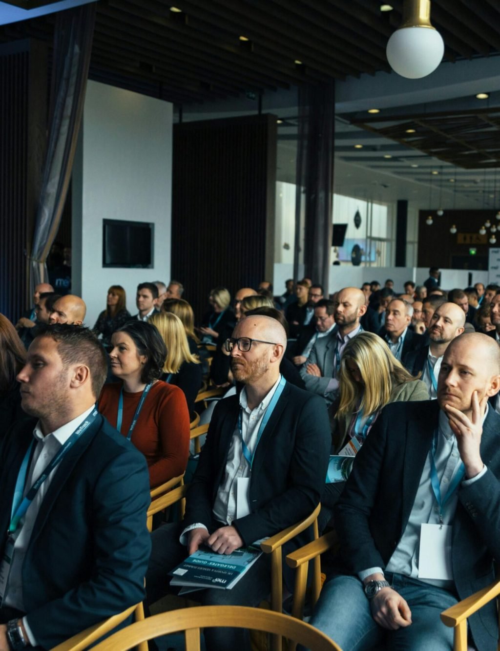 Business professionals attentively listening at an indoor conference meeting.